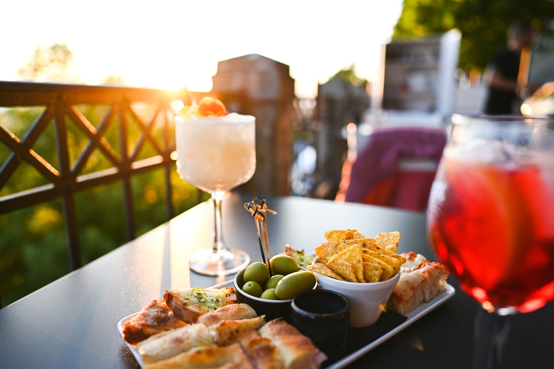 Enjoying aperitivo at sunset with cocktails and snacks on a terrace