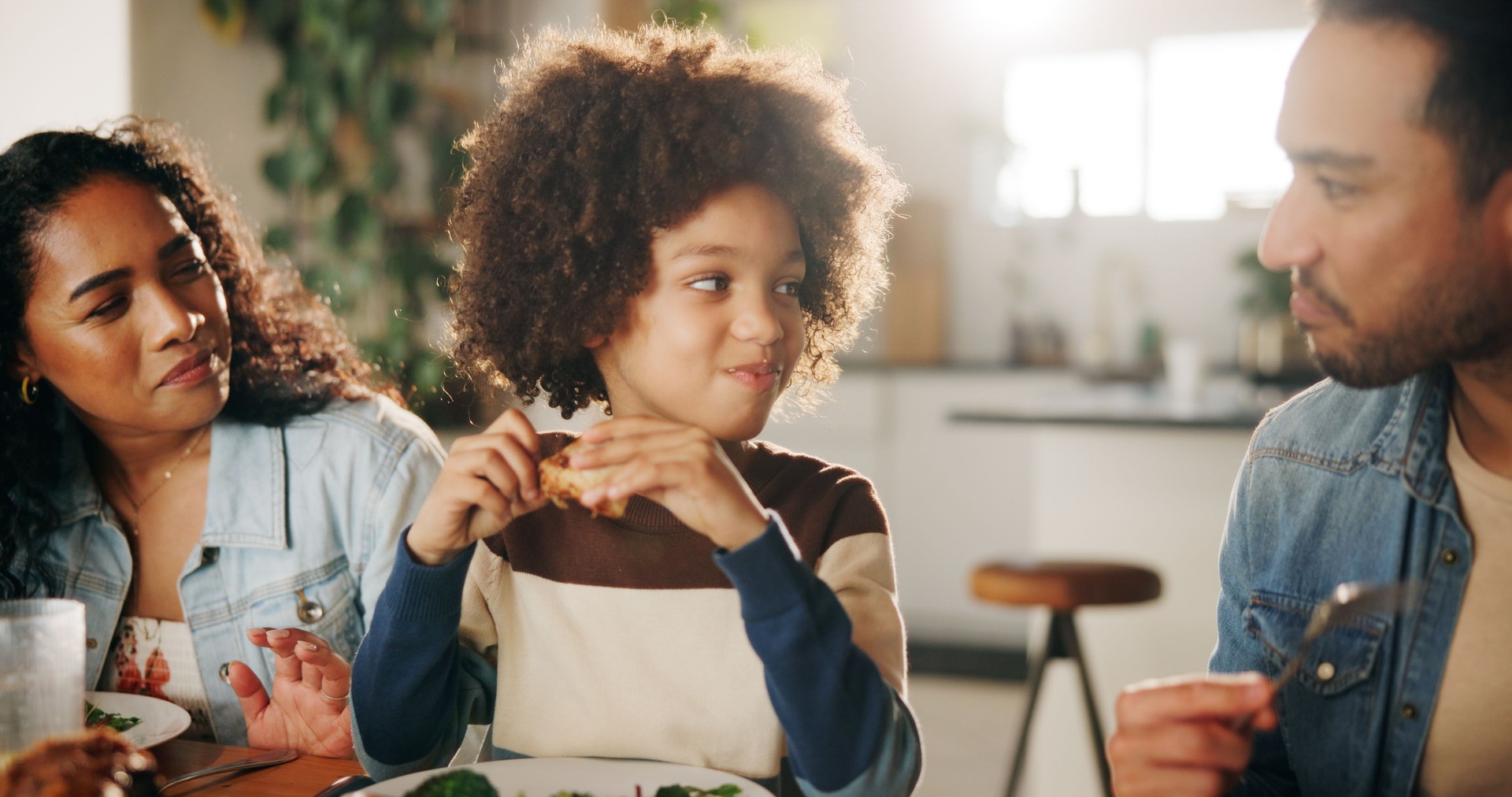 Eating, happy or parents with child in home for family dinner, healthy meal or bonding at dining table. Love, people or lunch together with food for nutrition, support or relationship with connection