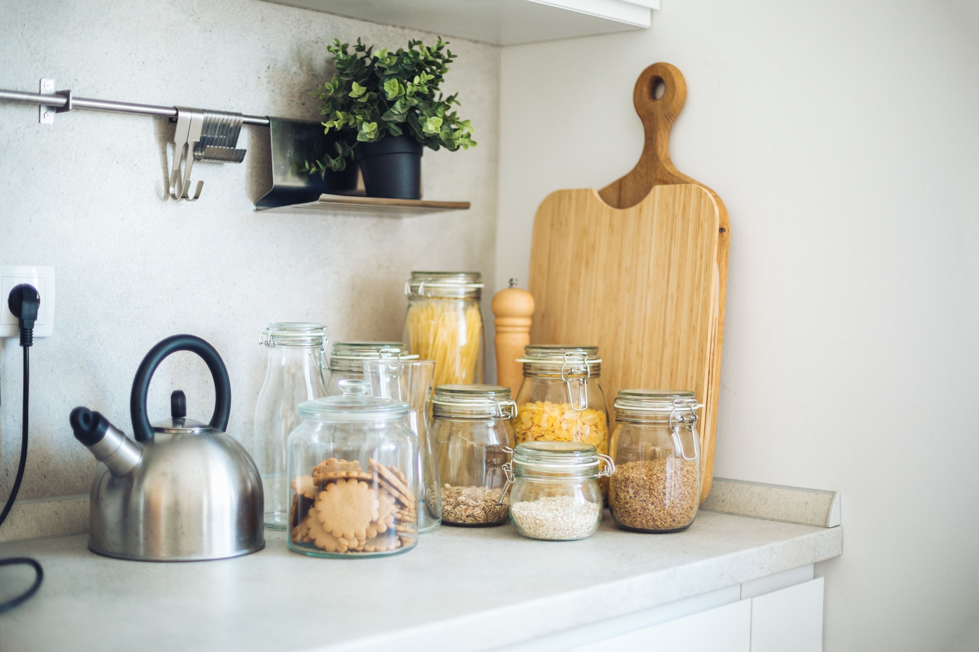 Modern kitchen countertop with food storage jars and kettle displaying zero waste lifestyle