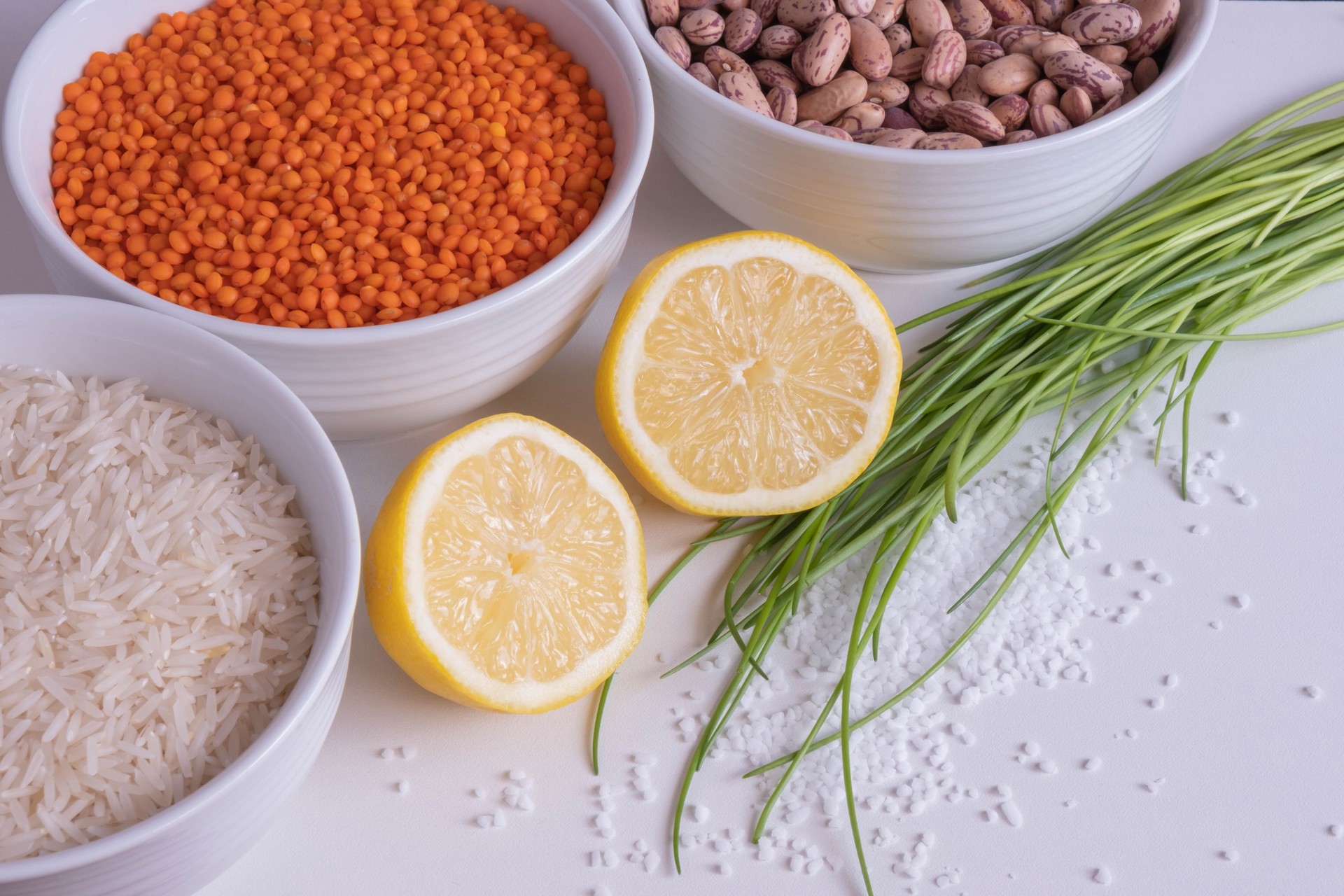 red lentils and beans in cups with lemon and herbs on the table